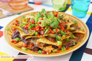 Nachos con queso, guacamole y chili con carne al horno